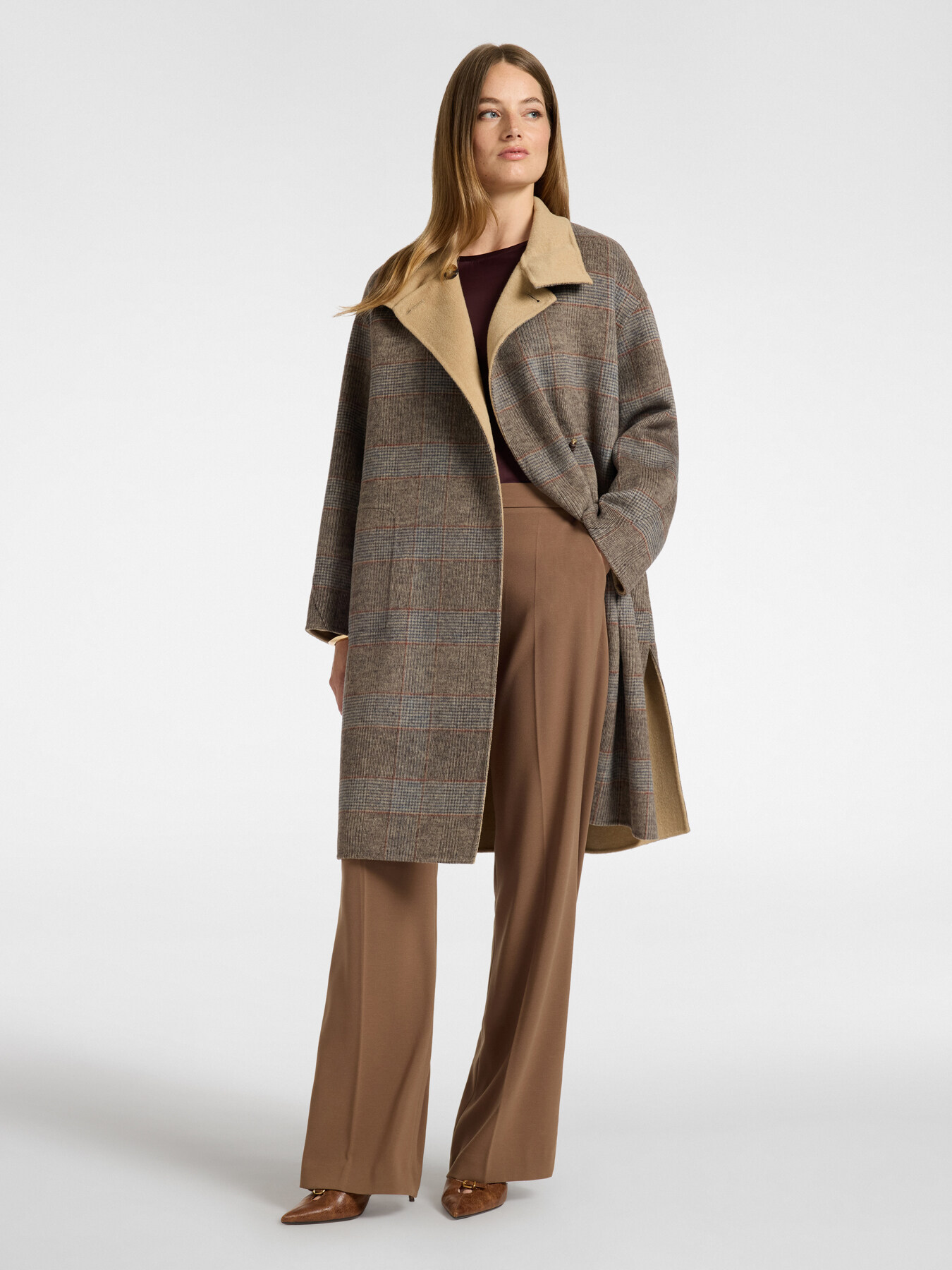 Abrigo de cuadros combinado con pantalón camel y jersey burdeos.